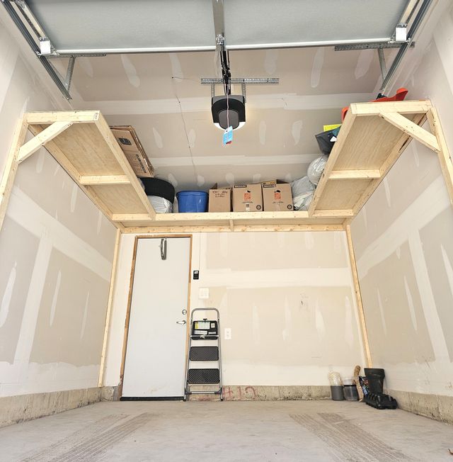 3-wall wrap-around wood garage shelving loaded with a winter tire, bins and boxes in a single garage in Toronto — built on-site by Toronto Garage Storage.