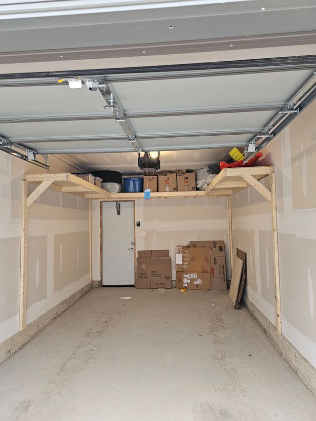 Loaded wood garage shelving built around the garage door tracks in a single garage in Toronto — built on-site by Toronto Garage Storage.