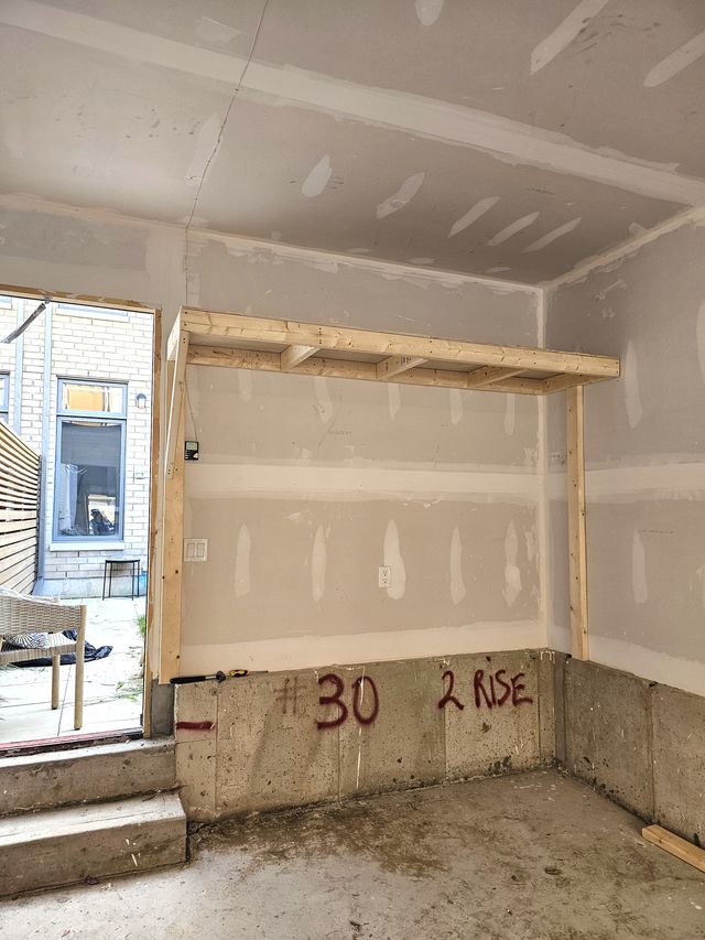 Overhead garage shelving frame mid-build above the side door of a single garage in Toronto — built on-site by Toronto Garage Storage.