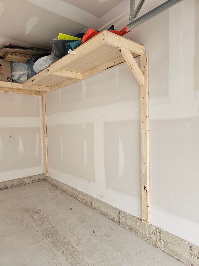 Close-up of the wood framing of overhead garage shelving — ledger board and diagonal brace — in a Toronto garage, built on-site by Toronto Garage Storage.