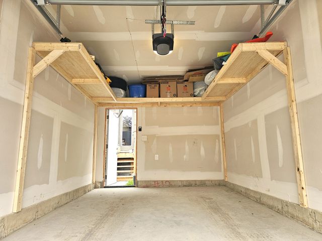 Wrap-around overhead wood garage shelving loaded with bins and boxes in a single garage in Toronto — built on-site by Toronto Garage Storage.